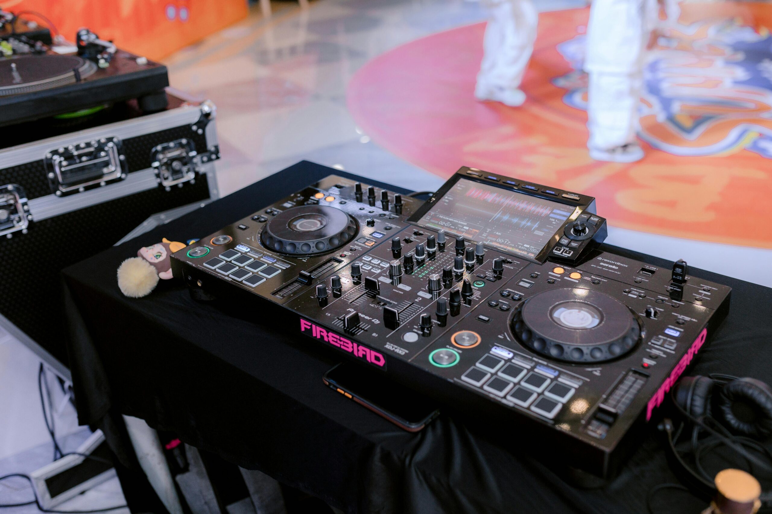 Close-up of professional DJ equipment setup, highlighting a digital mixer and turntable at an indoor event.